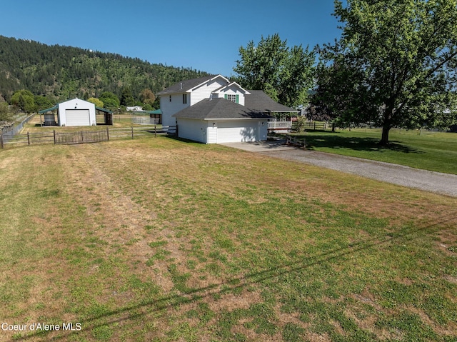 5904 N 15th St, Dalton Gardens, ID 83815 - view of yard with asphalt driveway, a wooded view, and a detached garage