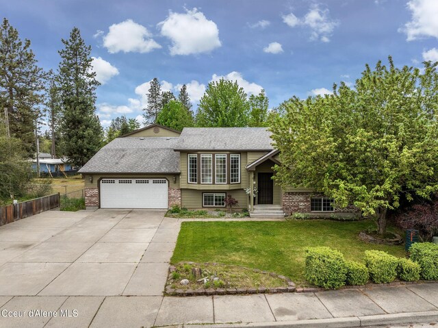 405 W 22nd Ave, Post Falls, ID 83854 - view of front facade with brick siding, driveway, an attached garage, and roof with shingles