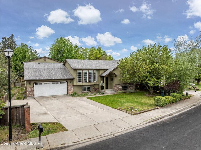 405 W 22nd Ave, Post Falls, ID 83854 - raised ranch featuring brick siding, a garage, concrete driveway, and roof with shingles