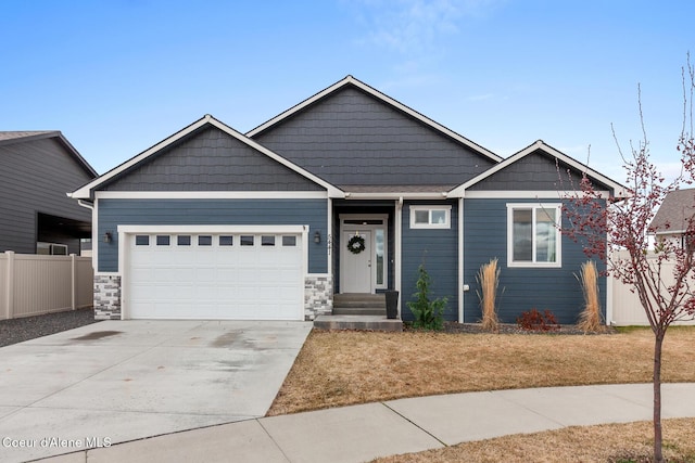 5441 W Gumwood Cir, Post Falls, ID 83854 - craftsman-style house featuring fence, stone siding, a garage, and concrete driveway