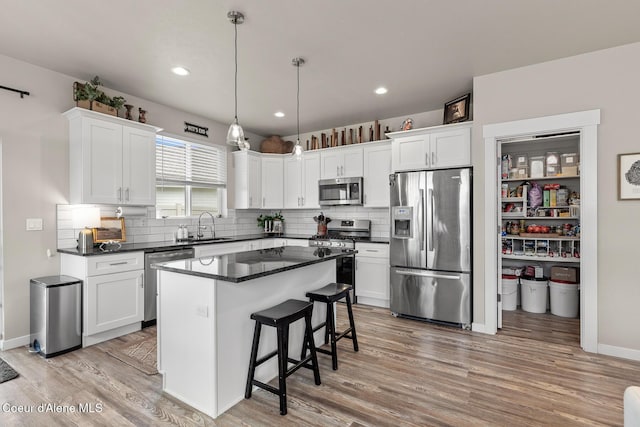 5441 W Gumwood Cir, Post Falls, ID 83854 - kitchen featuring white cabinets, a sink, dark countertops, and appliances with stainless steel finishes