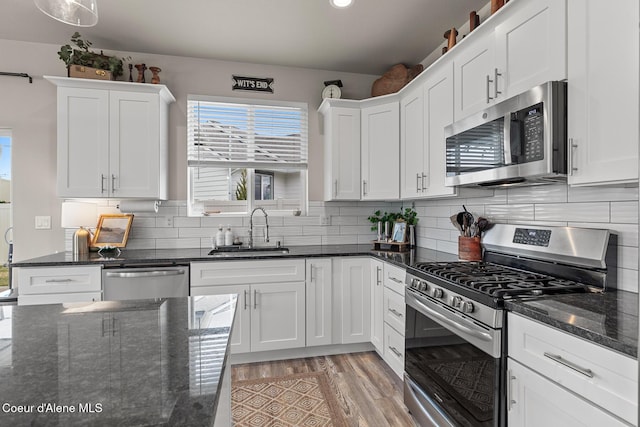 5441 W Gumwood Cir, Post Falls, ID 83854 - kitchen with white cabinetry, light wood-style floors, a sink, and stainless steel appliances