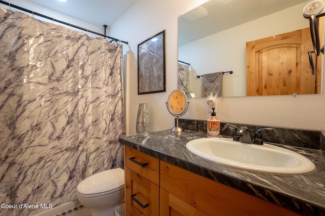bathroom with toilet, vanity, and curtained shower