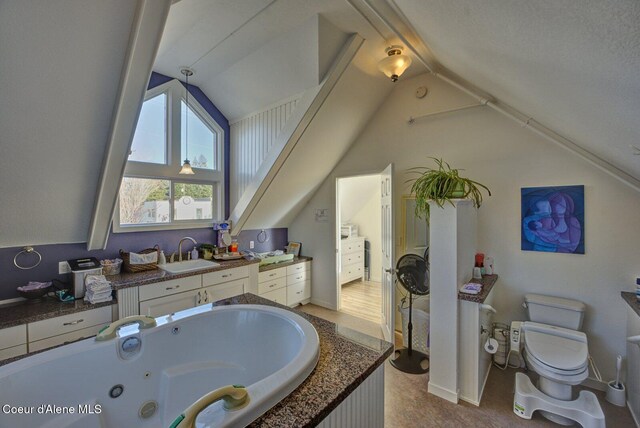 723 Pine St, Sandpoint, ID 83864 - bathroom featuring toilet, vanity, a jetted tub, and lofted ceiling