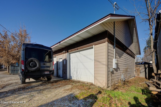 723 Pine St, Sandpoint, ID 83864 - view of side of home with driveway, a detached garage, and an outbuilding