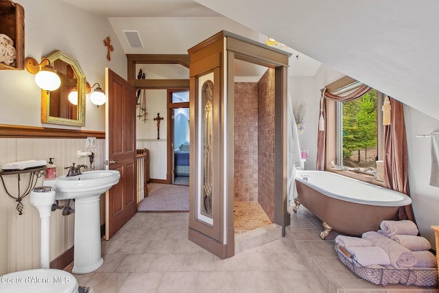 3467 E Sunset Dr, Harrison, ID 83833 - bathroom featuring tile patterned flooring, tiled shower, a soaking tub, and a wainscoted wall
