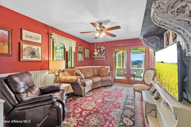 3467 E Sunset Dr, Harrison, ID 83833 - carpeted living room featuring a ceiling fan and wainscoting