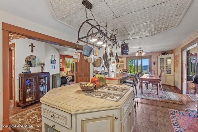 3467 E Sunset Dr, Harrison, ID 83833 - kitchen with cream cabinets, ceiling fan, an ornate ceiling, stone tile floors, and white gas cooktop