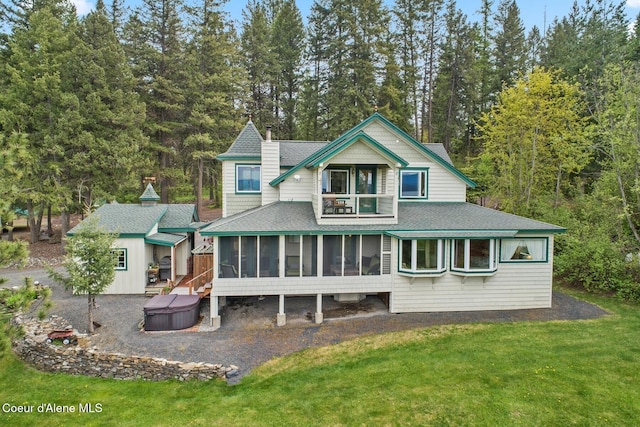 3467 E Sunset Dr, Harrison, ID 83833 - back of house featuring a hot tub, a sunroom, a shingled roof, and a yard