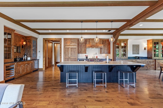 4669 S Arrow Point Dr # 210, Harrison, ID 83833 - kitchen with decorative backsplash, light countertops, beamed ceiling, wine cooler, and dark wood-style floors