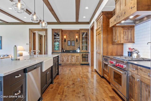 4669 S Arrow Point Dr # 210, Harrison, ID 83833 - kitchen featuring light wood-style flooring, wine cooler, high end appliances, wall chimney range hood, and backsplash