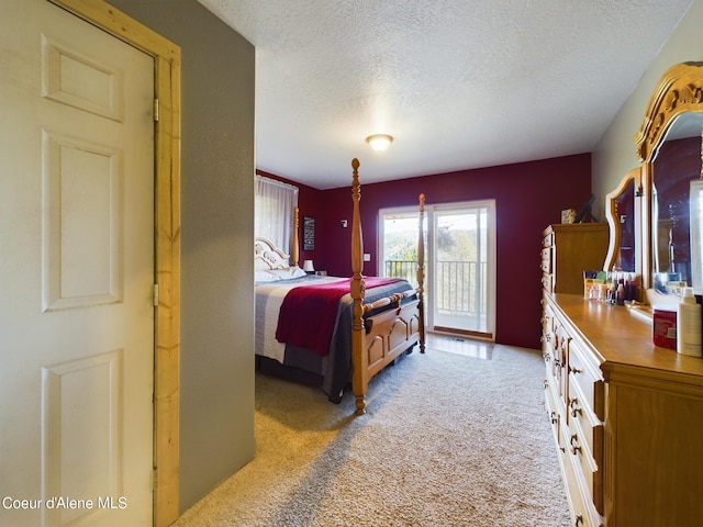 bedroom featuring carpet flooring, access to exterior, and a textured ceiling