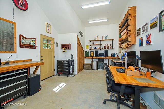 office space featuring concrete flooring, visible vents, and a workshop area