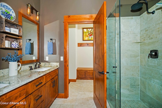 full bathroom featuring double vanity, a sink, a stall shower, and tile patterned floors