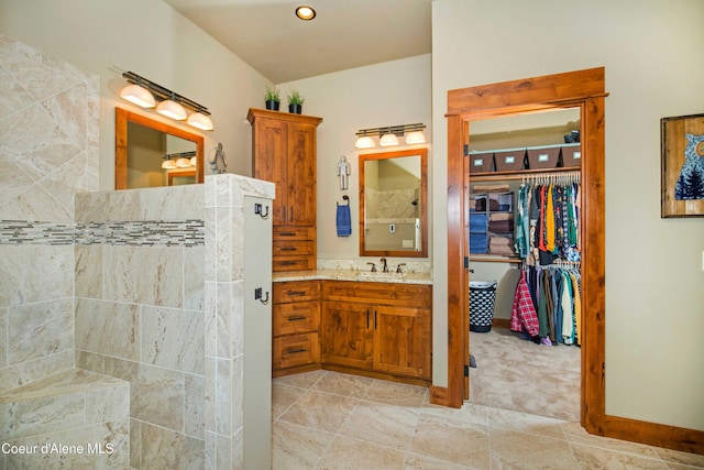 full bath with vanity, a spacious closet, and walk in shower