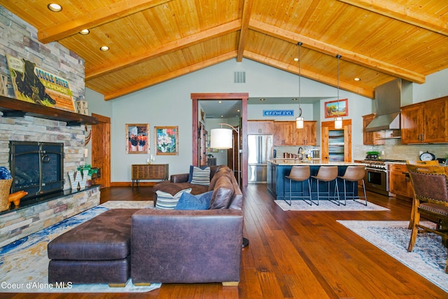 living area with dark wood-type flooring, a fireplace, visible vents, and wooden ceiling