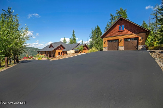 rustic home with stone siding and an outbuilding
