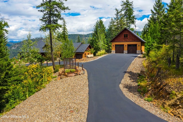 view of front of home featuring an outdoor structure, a detached garage, and stone siding
