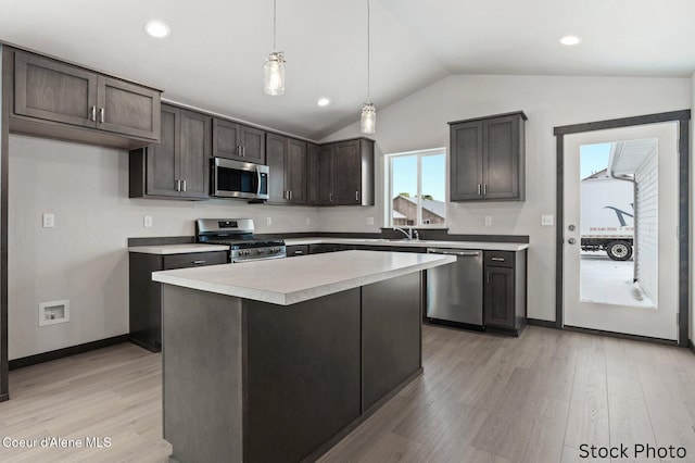 11669 N Railway Ave, Rathdrum, ID 83858 - kitchen with stainless steel appliances, lofted ceiling, dark brown cabinetry, light wood finished floors, and light countertops