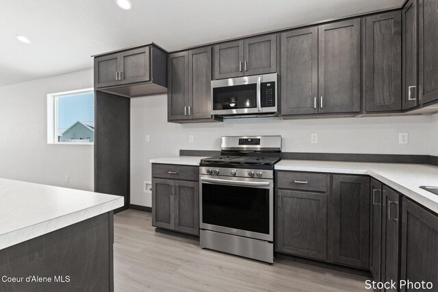 11669 N Railway Ave, Rathdrum, ID 83858 - kitchen featuring appliances with stainless steel finishes, light countertops, light wood-style flooring, recessed lighting, and dark brown cabinetry