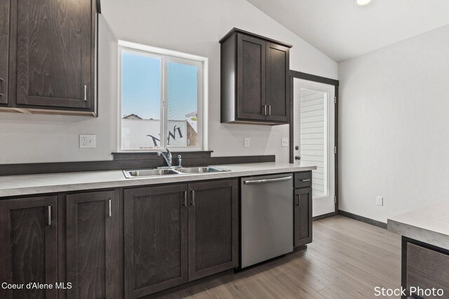 11669 N Railway Ave, Rathdrum, ID 83858 - kitchen with stainless steel dishwasher, a sink, dark brown cabinets, vaulted ceiling, and light wood-type flooring