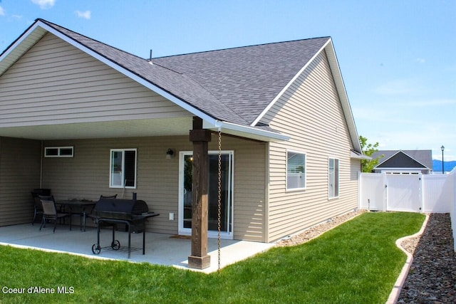 12379 N Cavanaugh Dr, Rathdrum, ID 83858 - rear view of house with roof with shingles, a gate, and a patio area