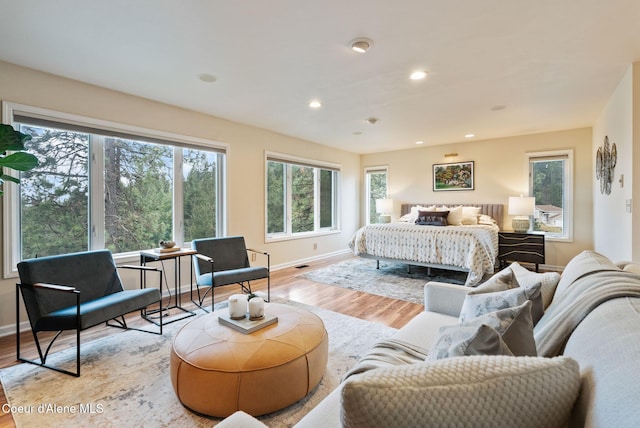 bedroom with baseboards, light wood finished floors, and recessed lighting