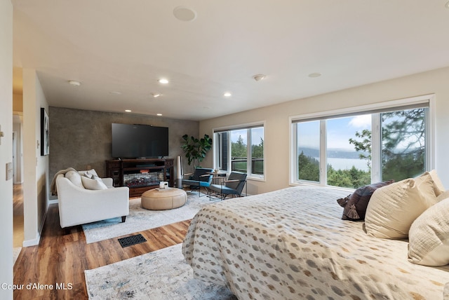 bedroom featuring baseboards, visible vents, wood finished floors, and recessed lighting