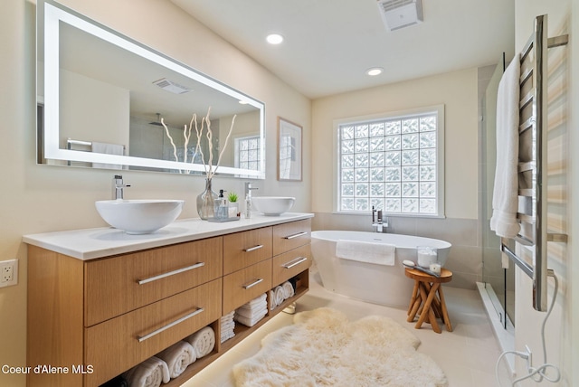 full bath with a sink, double vanity, visible vents, and walk in shower