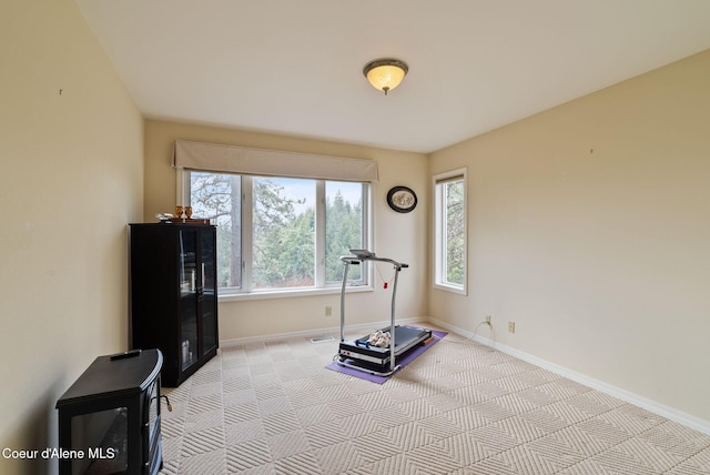 workout room with light carpet and baseboards