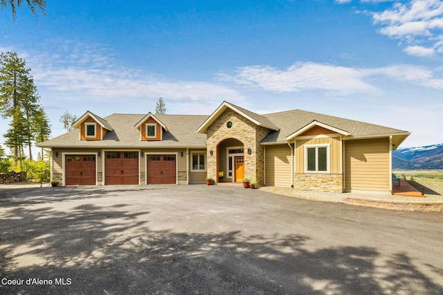 view of front facade featuring stone siding, a garage, board and batten siding, driveway, and a shingled roof