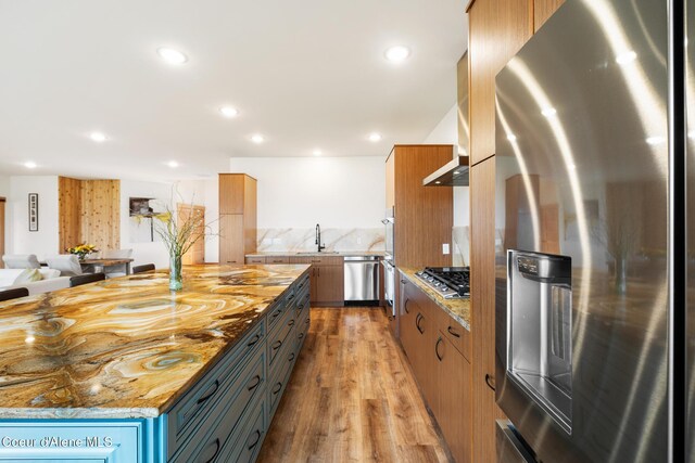 kitchen with open floor plan, recessed lighting, stainless steel appliances, a sink, and light wood-style floors