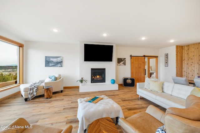 living room with light wood-style flooring, baseboards, a fireplace, and recessed lighting