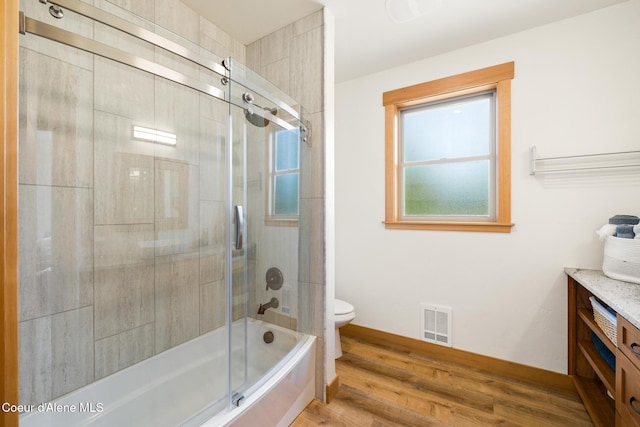 bathroom with visible vents, baseboards, toilet, wood finished floors, and vanity