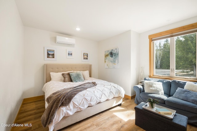 bedroom featuring baseboards, recessed lighting, wood finished floors, and an AC wall unit