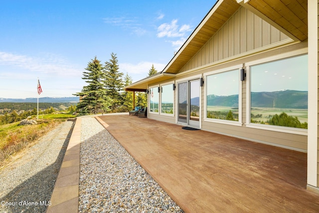 view of property exterior featuring board and batten siding, a patio area, and a mountain view