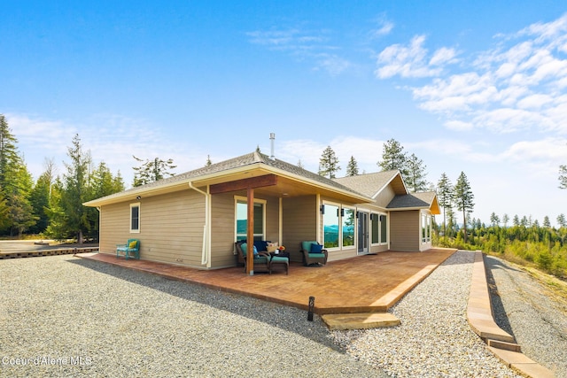 back of house featuring a patio and a shingled roof