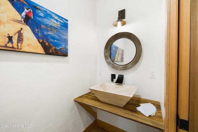 bathroom featuring baseboards and a sink