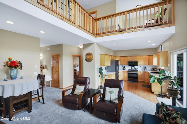 living room with baseboards, a high ceiling, and recessed lighting
