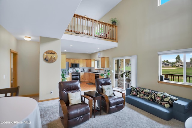 living room featuring baseboards, light colored carpet, a towering ceiling, and recessed lighting