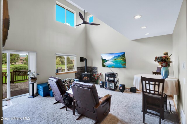 carpeted living room with a towering ceiling, a wood stove, and recessed lighting