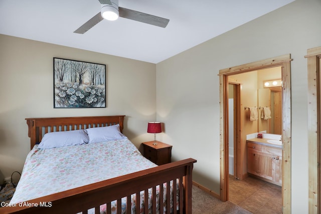 bedroom featuring baseboards, ensuite bath, and ceiling fan