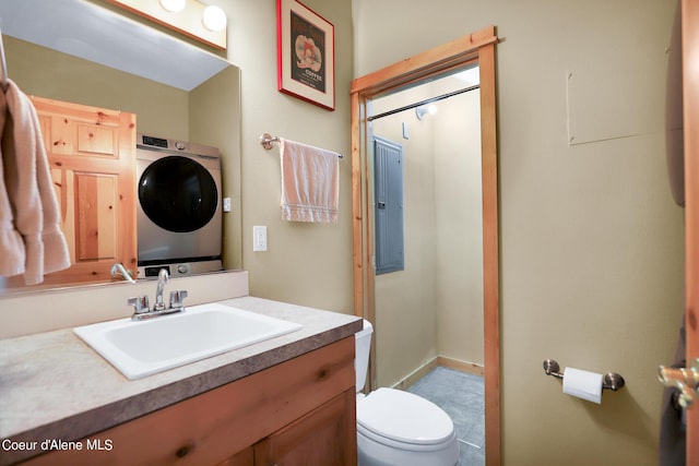 bathroom with stacked washer and dryer, toilet, and vanity