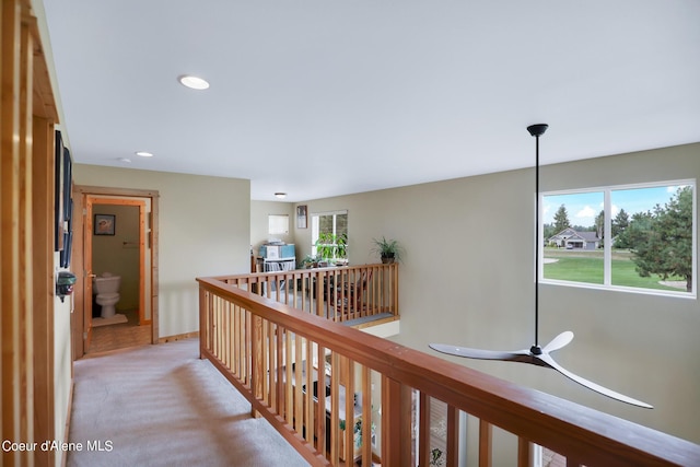 corridor featuring baseboards, an upstairs landing, recessed lighting, and carpet