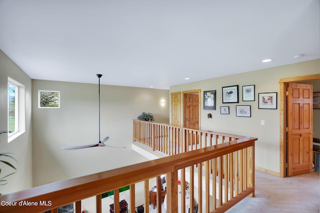 hallway with light carpet, baseboards, an upstairs landing, and recessed lighting