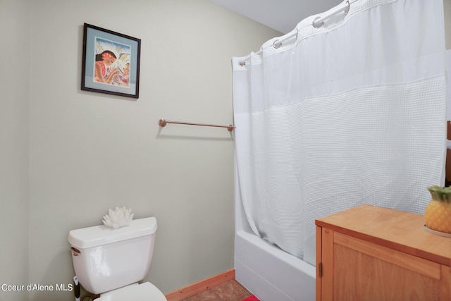 bathroom featuring baseboards, shower / tub combo with curtain, toilet, and tile patterned floors