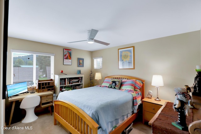 bedroom with a ceiling fan, multiple windows, and light colored carpet