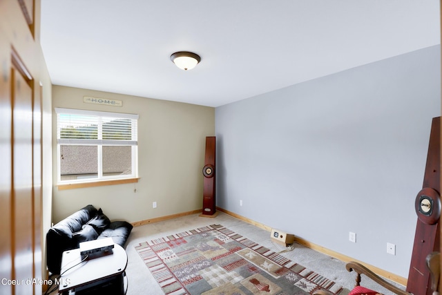 sitting room with baseboards and light colored carpet