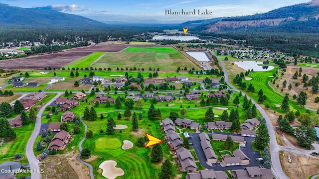 birds eye view of property featuring view of golf course, a residential view, and a water and mountain view