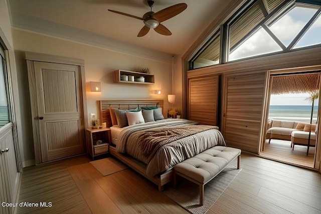 bedroom with ceiling fan, wood finished floors, and a water view
